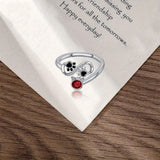 Anillo ajustable con huellas negras y una gema roja