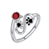 Anillo ajustable con huellas negras y una gema roja