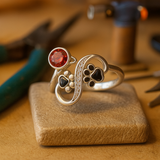 Anillo ajustable con huellas negras y una gema roja